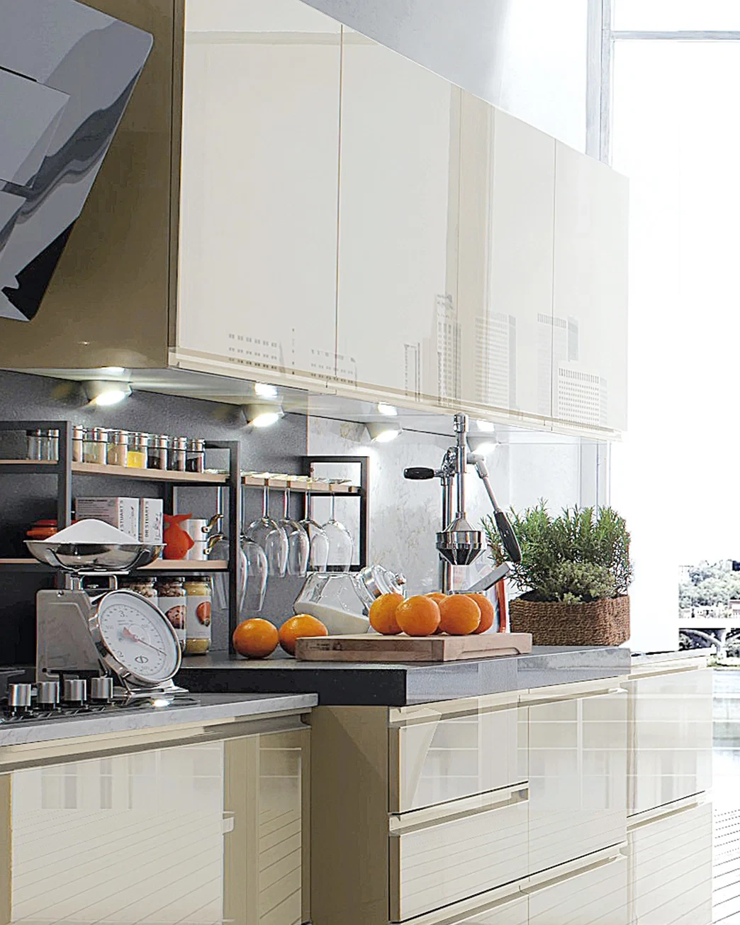 Naturally lit kitchen preparation area with citrus, a cutting board and stainless steel tools.
